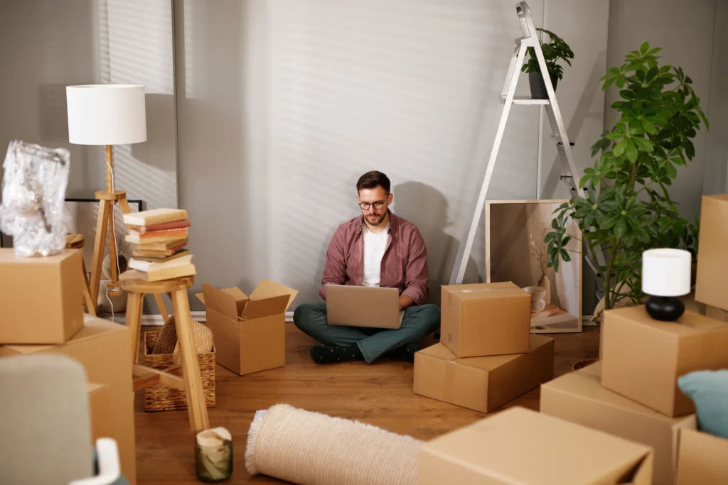 man sits in his living room researching secured vs unsecured loans on his laptop | Swoosh Finance NZ