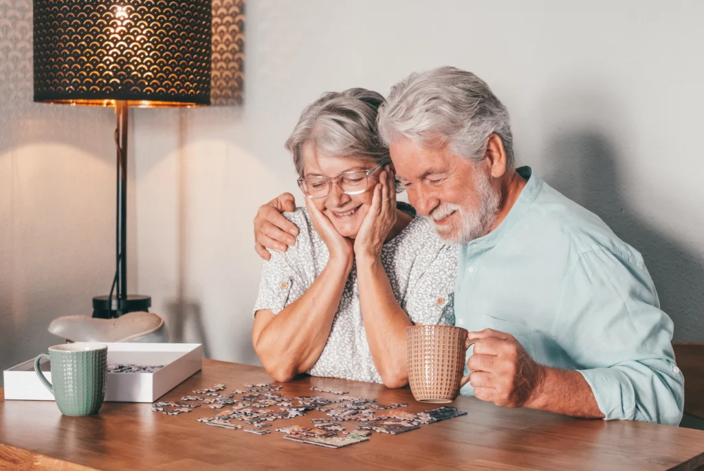 Older couple doing a puzzle together while drinking tea