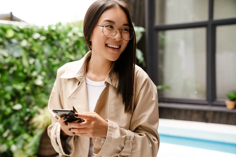 Woman on her phone smiling because she got approved for a Bad Credit Loan with Swoosh Finance NZ