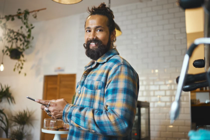 man with beard and nose piercings applying for an emergency loan on his phone