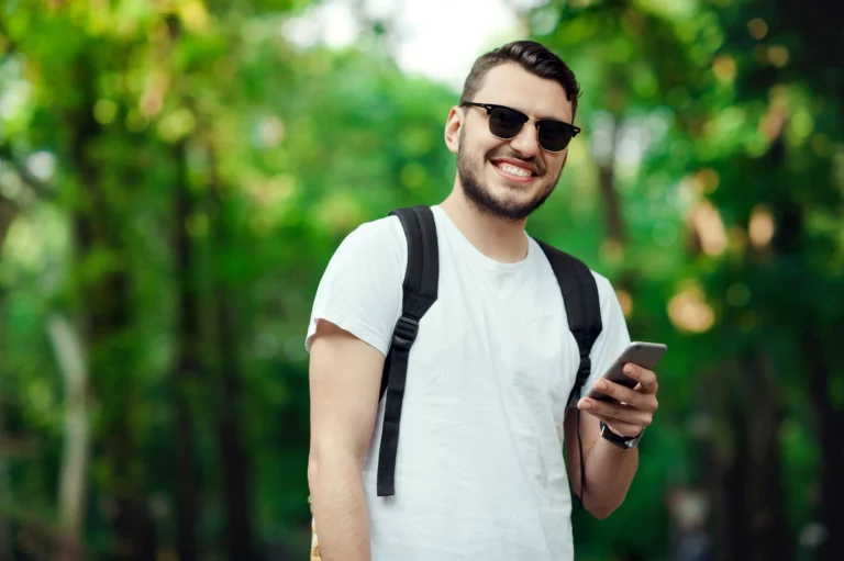 man walking outside happy on his phone as he applies for a payday loan