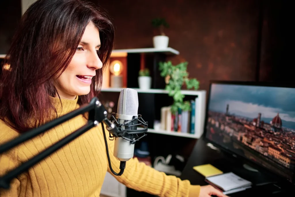 Woman recording a voiceover at her desk with a microphone as a side gig to make extra money
